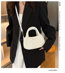 Detail of white semi-circle leather handbag featuring gold Fashion & Bags lettering
