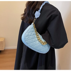 Dettaglio borsa hobo trapuntata azzurra con catena dorata e trama a tracolla intrecciata