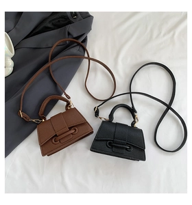 Close-up of brown and black pebbled leather mini crossbody bags with gold hardware