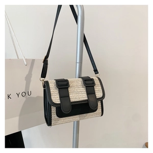 Vue macro de la texture tissée beige et des finitions en cuir noir d'un sac bandoulière