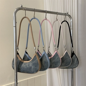 Minimalist denim crescent underarm bags in five colors hanging on a stainless steel rack
