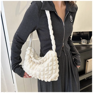 Vue détaillée du tissu blanc à texture gaufrée sur ce sac à bandoulière élégant pour femmes