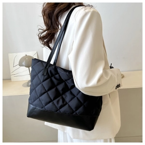 Fashionable black quilted tote bag with large capacity shown on a model for daily use