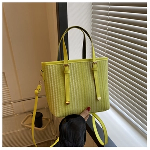 Detailed view of fresh green tote bag featuring vertical striped texture and gold hardware