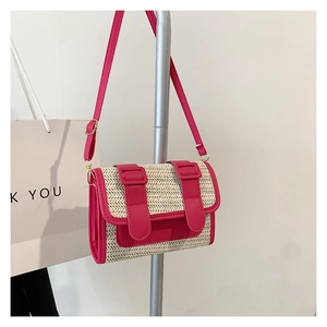 Détail du tissage en paille et des finitions en similicuir rose sur le sac à bandoulière