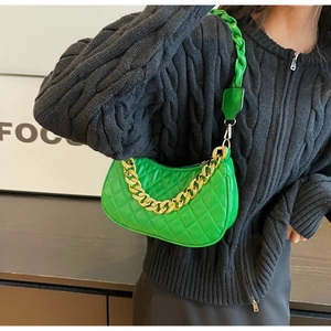 Dettaglio della borsa trapuntata verde brillante con catena dorata e tracolla in tessuto