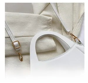 Close-up of white crossbody bag with gold hardware and FASHION & BAGS lettering