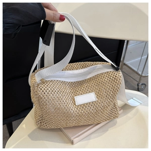 Détail du sac bandoulière en paille tissée avec sangle en tissu blanc et fermeture