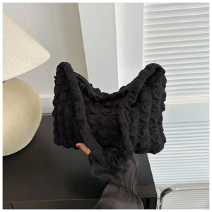 Détail de la texture à bulles noire sur un grand sac cabas porté épaule élégant