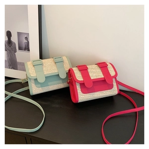 Détail de sacs bandoulière en paille tissée et similicuir bleu et magenta pour l'été