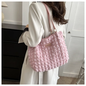 Close-up of pink puff textured tote bag with a leather Fashion label and handle