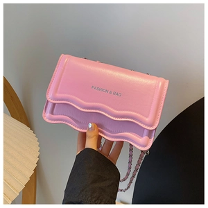 Detail of pink small square bag featuring wavy edges and silver chain strap for women