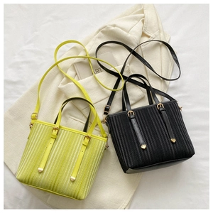 Detailed view of the striped vertical weave texture and metal hardware on bucket bags