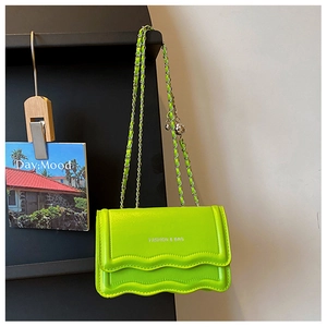 Detail of neon green chain bag featuring wavy texture and white fashion typography