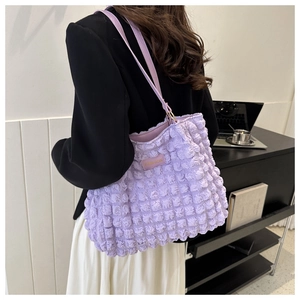 Detail of light purple bubble texture tote bag with fashion label and slim shoulder strap