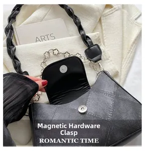 Détail du fermoir magnétique argenté sur un sac à bandoulière noir pour femmes