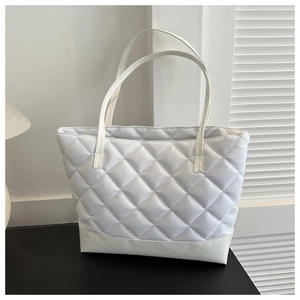 Detail of white quilted oxford tote bag with diamond stitching and slim shoulder straps