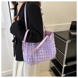 Detail of purple bubble textured tote bag with pleated design and golden fashion plaque