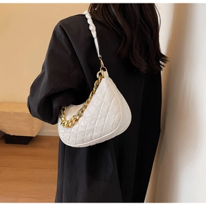 Dettaglio della borsa hobo bianca trapuntata con catena dorata sulla spalla della donna