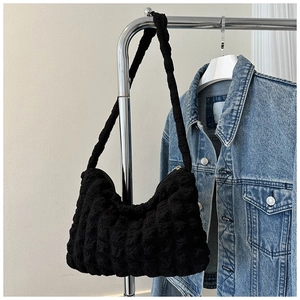 Gros plan sur la texture à bulles et le tissu gaufré de ce sac à main noir