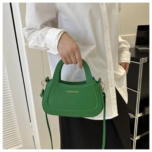 Detailed view of a green semi-circle crossbody bag with golden Fashion & Bags logo