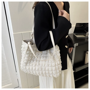 Close-up of white puffer tote bag with bubble texture and fashion logo patch