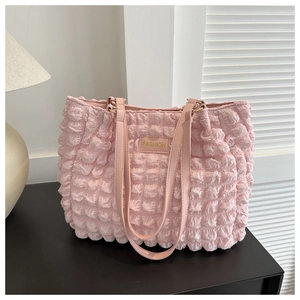 Detail of pink popcorn textured tote bag showing 3D fabric and leather Fashion label