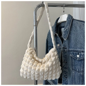 Vue détaillée du tissu blanc à bulles et des fronces du sac fourre-tout minimaliste