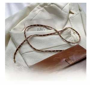 Detail of vintage brown crossbody bag with metal moon clasp and woven chain strap