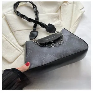 Détail du sac bandoulière vintage gris avec chaîne argentée et poignée en cuir