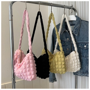 Détails des sacs fourre-tout à texture bulles en rose noir jaune et blanc sur un cintre