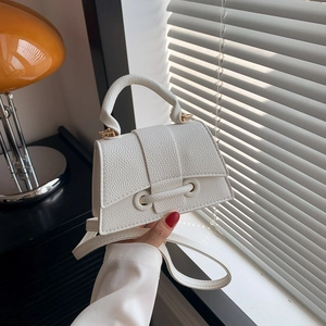 Elegant white litchi pattern PU leather trapezoid handbag with a vintage gold metal bar