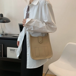 Chic beige lychee leather bucket bag with perforated H design and shoulder strap
