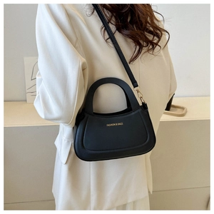 Model view of a black crescent crossbody bag with gold metal hardware and fine leather texture