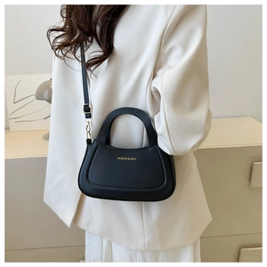 Detail of black matte leather crossbody bag with gold metal buckle and FASHION & BAGS logo