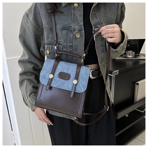 Détail du sac à dos vintage en similicuir marron et denim bleu avec boucles en métal