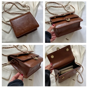 Detail view of vintage brown leather square bag showing interior space and chain strap
