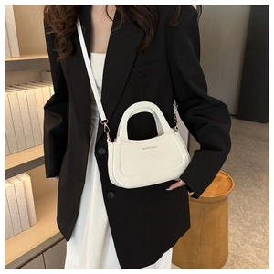 Detail of white leather handbag with gold buckle and Fashion & Bags text on black blazer