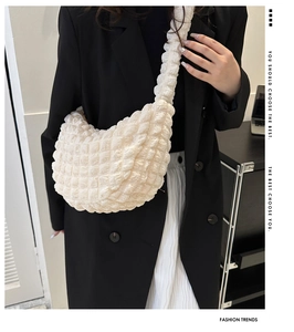 Detail of white bubble texture hobo bag worn by model with minimalist fashion aesthetic