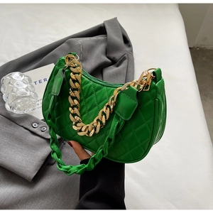 Dettaglio borsa trapuntata verde brillante con catena dorata e tracolla in pelle intrecciata