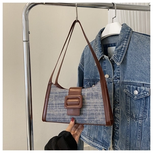 Détail du sac à bandoulière en tweed bleu avec bordure en cuir marron et boucle