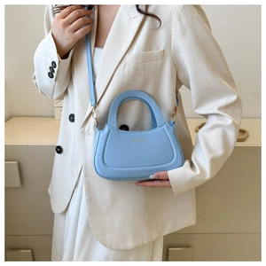 Light blue crossbody bag with Fashion & Bags lettering worn with a white blazer