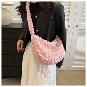 Pink pleated cloud bag detail showing puffy bubble texture worn with leather jacket