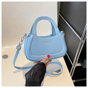 Detail of light blue PU leather handbag showing golden hardware and detachable strap