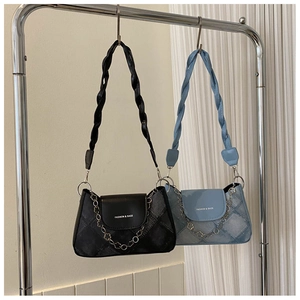 Détail de sacs sous les aisselles en denim avec bandoulières tressées et accents de chaîne