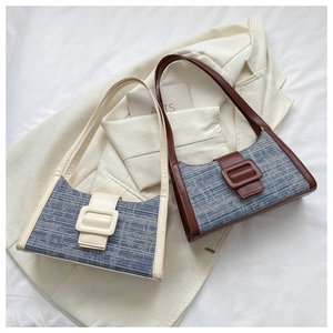 Détail de la texture en tissu à carreaux et bandoulière en cuir synthétique du sac baguette