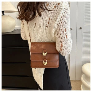 Brown vintage leather shoulder bag with double gold crescent buckles and chain strap