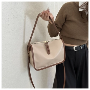 Detail showing elegant cream white tote with dark brown trim and metallic top zipper closure