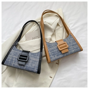 Détail du sac baguette rétro avec tissu en tweed et une grande boucle en cuir