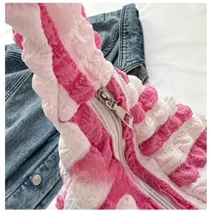 Close-up of the smooth metal zipper on pink and white textured seersucker fabric detail